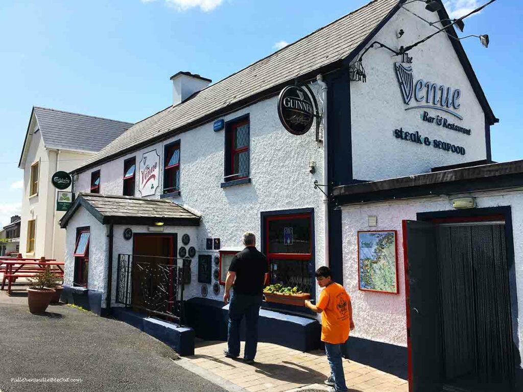 A father and son walking into a restaurant called The Venue